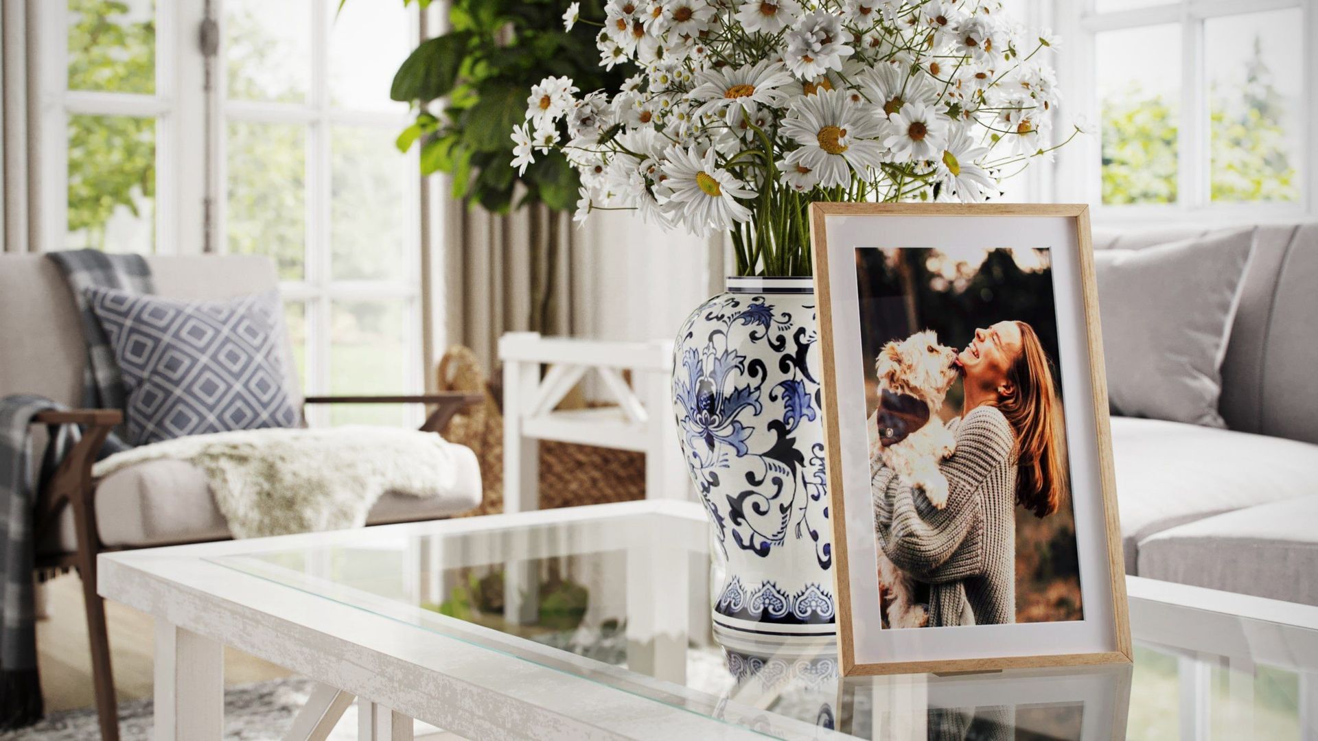 Lifestyle Rendering Of A Bright Living Room With A Glass Table, Flower Vase, And A Framed Photo