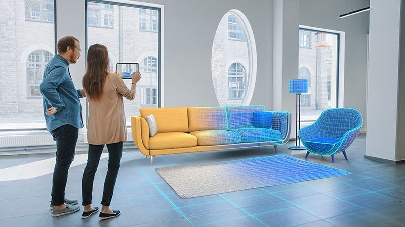 A couple using an app to view an AR model and see how the furniture will look in their room.