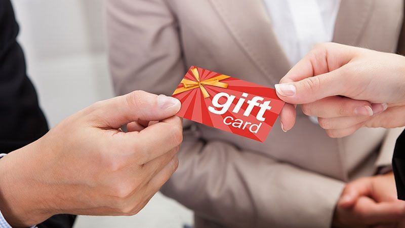 A Person Passing a Brand Gift Card which is a Perfect Collateral Item