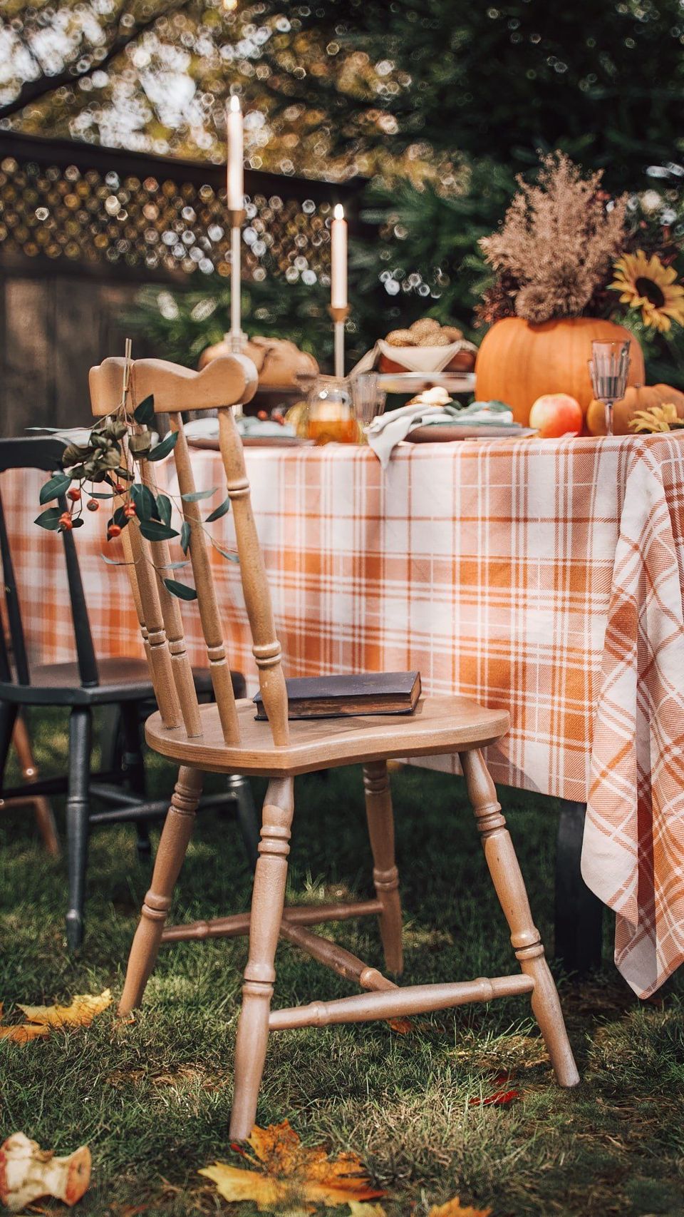 3D product modeling and rendering of an autumn-themed outdoor dining setup with wooden chairs and a plaid tablecloth.