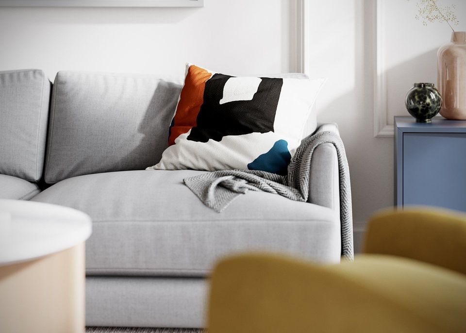 3D Rendering Of A Minimalist Sofa With A Bold Abstract Pillow And A Gray Throw Blanket