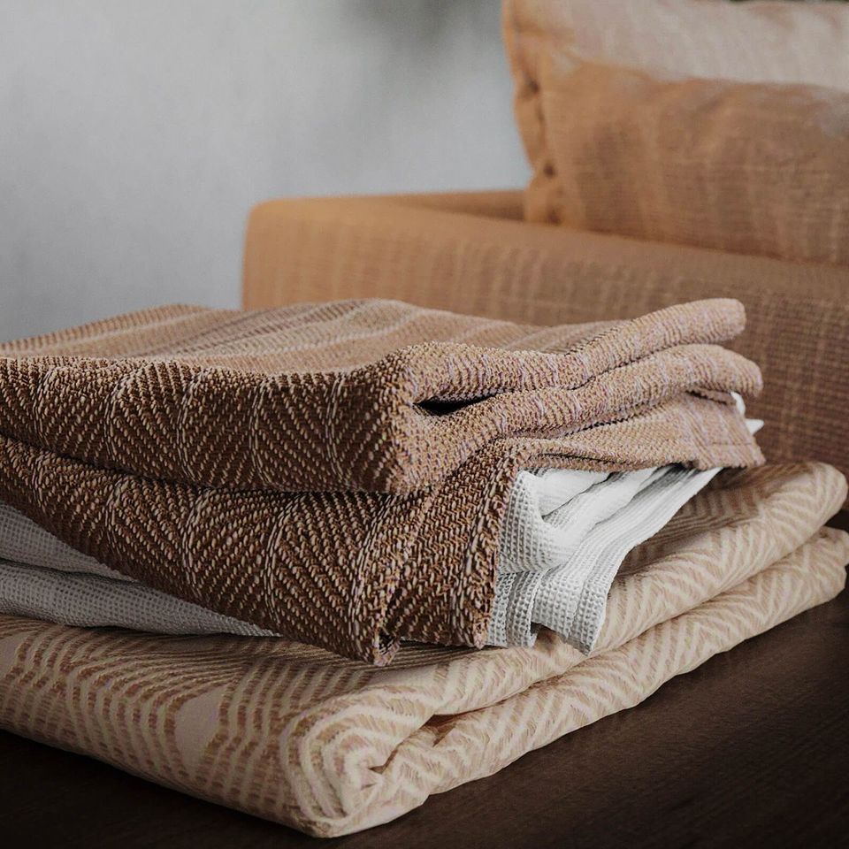 High-quality photorealistic 3D rendering of folded textiles on furniture, showcasing 3D furniture modeling and visualization.