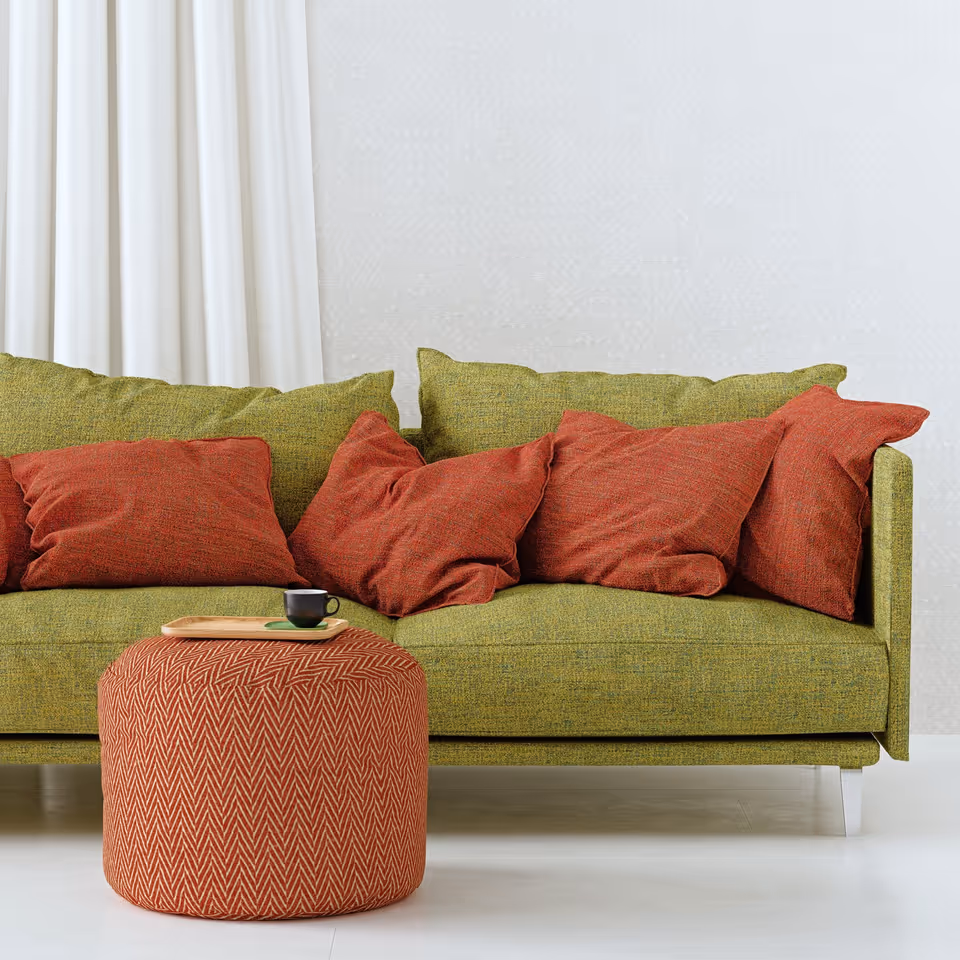 3D furniture rendering of a modern green sofa with red cushions and an ottoman, showcasing photorealistic 3D interior visualization and product modeling.