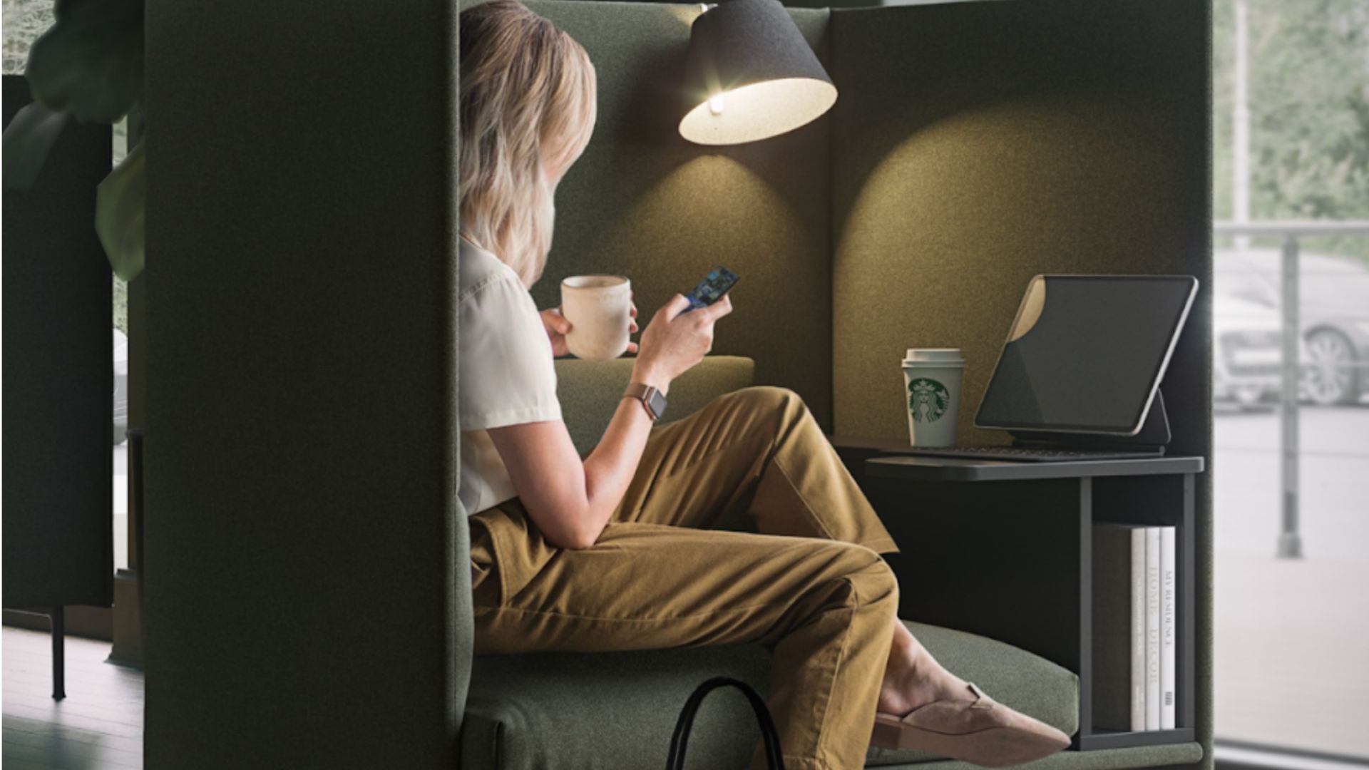A customer relaxes in a modern café booth, sipping coffee and browsing on her smartphone, potentially engaging with interactive content such as quizzes and polls next to a laptop and a Starbucks cup.