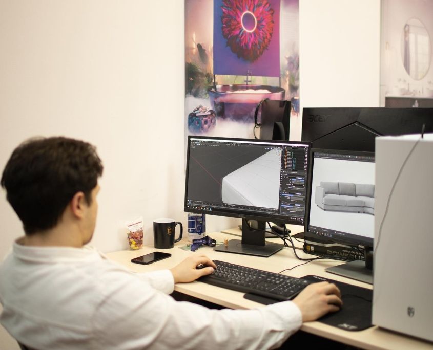 3D artist using rendering software for a project in an office