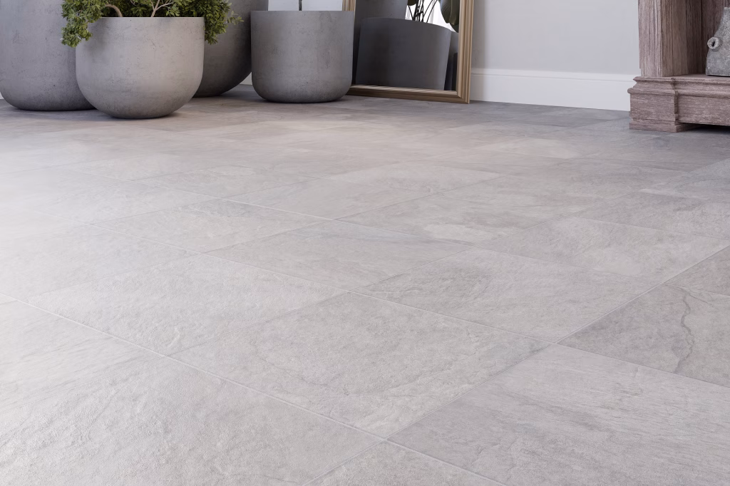 Flooring product rendering close-up of light grey stone tiles with concrete planters and a gold-framed mirror