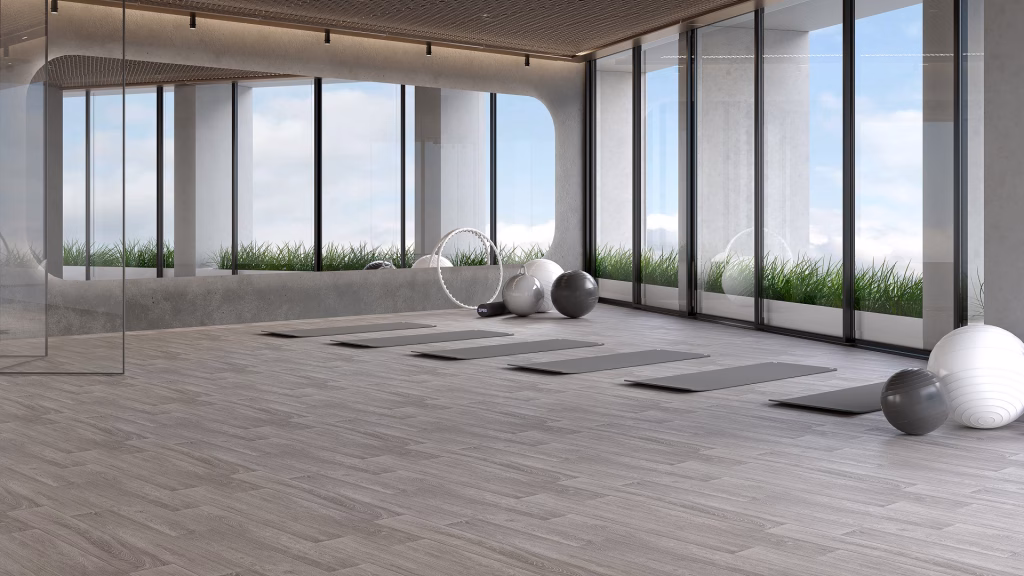 Flooring product rendering of Xtreme Pure Oak vinyl planks in a gym with yoga mats and exercise balls