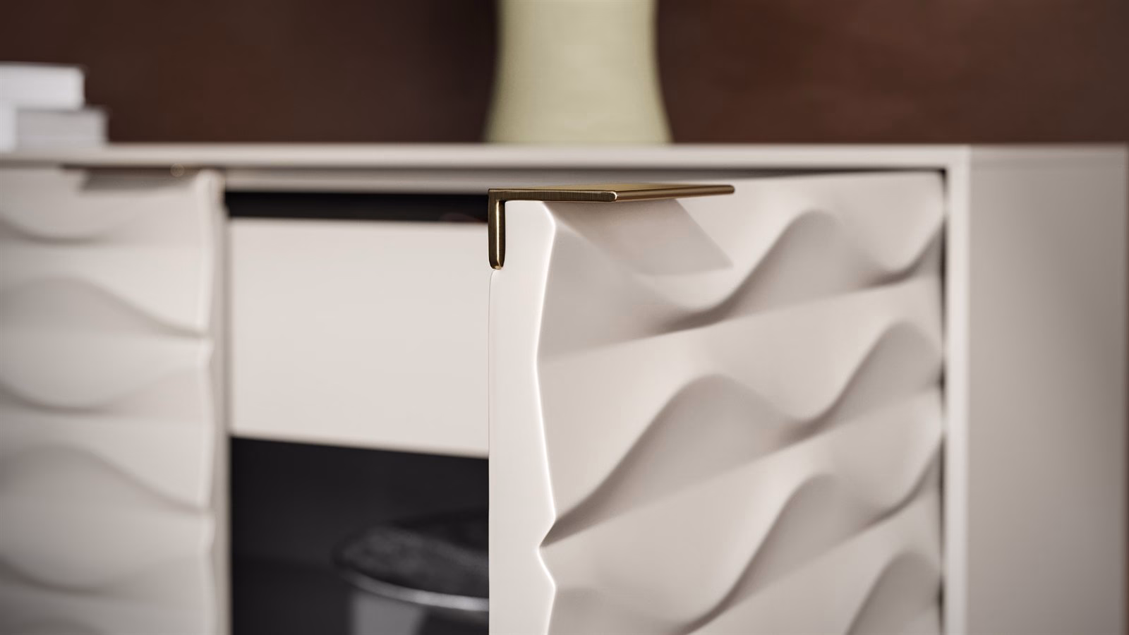 Close-up of the sculpted wave door and brass pull on the BDI Ripple credenza