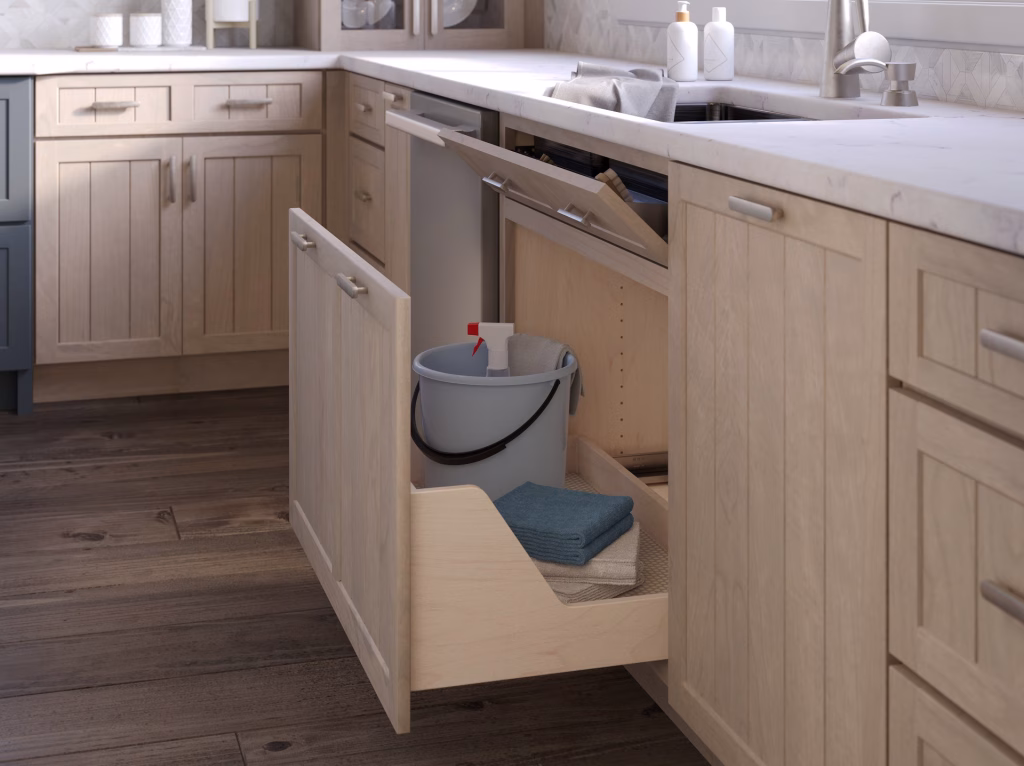 3D visualization of an open under-sink cabinet with pull-out cleaning caddy in a light oak kitchen