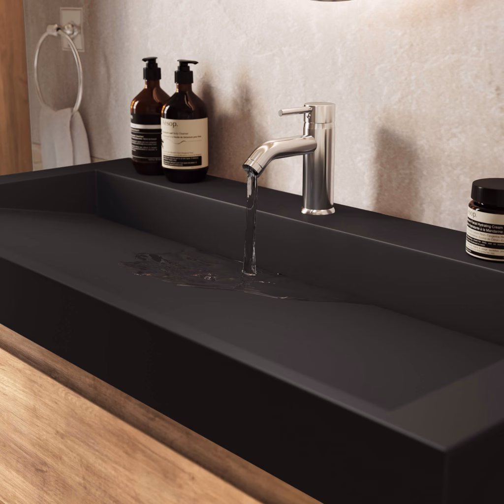Close-up CGI of water running from a chrome faucet into the wide black basin of a 100 cm oak vanity