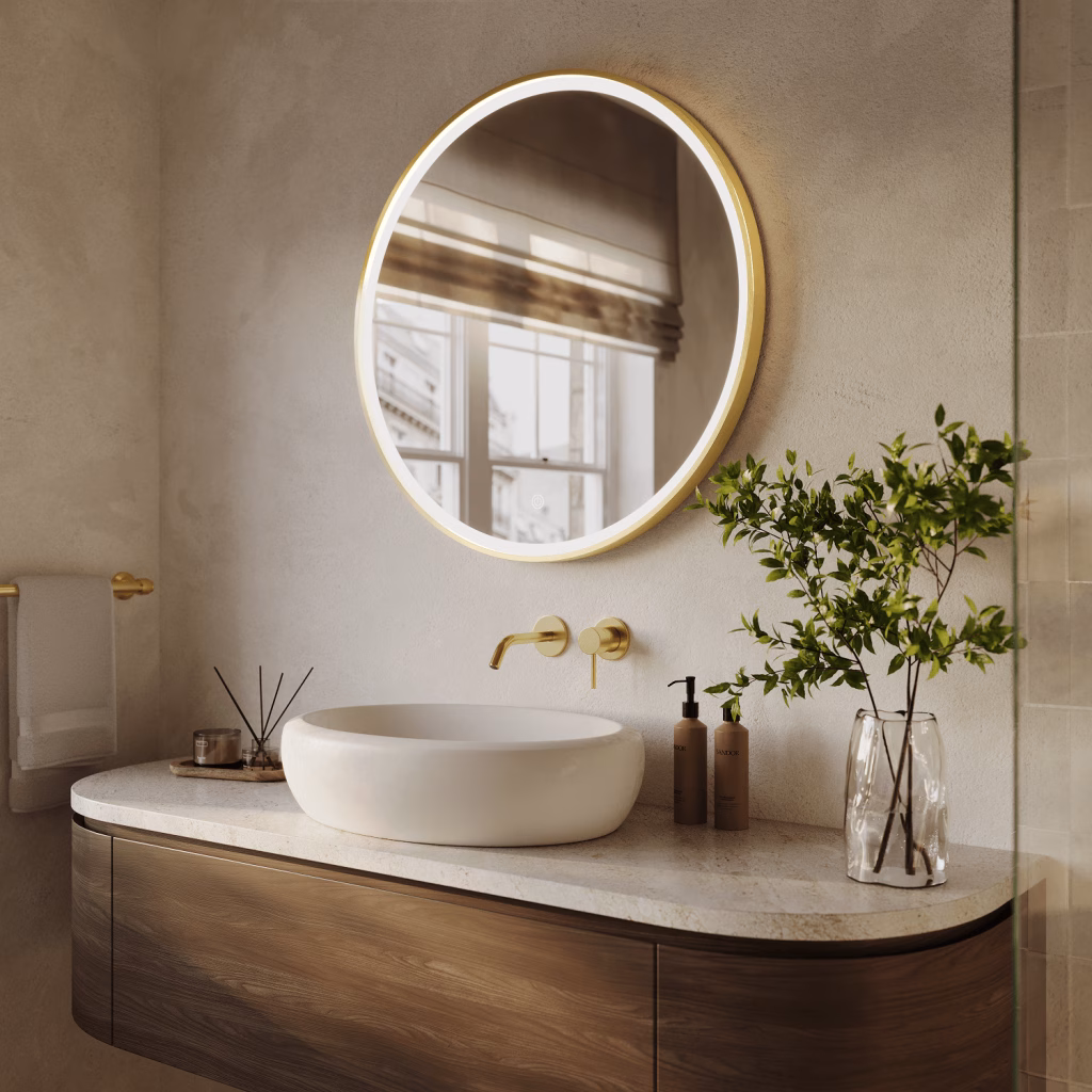 Angled 3D rendering of a large round gold-framed LED mirror above a vessel basin and brushed gold wall faucet