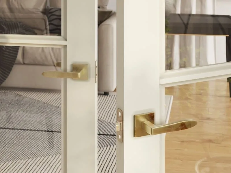 3D render of gold lever handles on white glazed interior doors