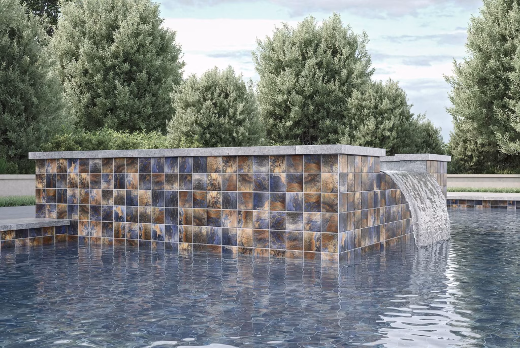 3D visualization of a raised pool wall in blue and copper stone-look tile, with an arched water spout falling into the pool