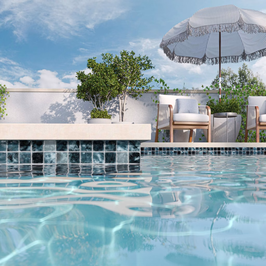 Pool tile rendering of dark teal glass mosaic along the waterline of a raised pool wall, with lounge chairs and a striped umbrella on the patio