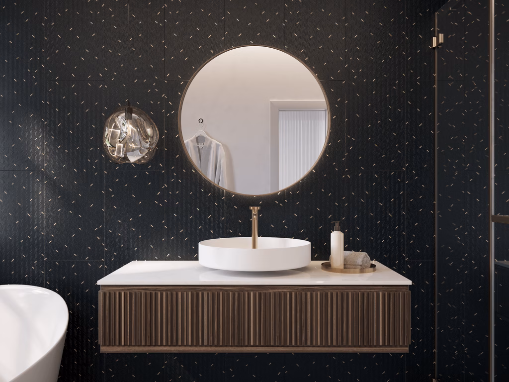 3D render of a bathroom vanity wall in black textured tile with scattered gold inlay, behind a round mirror and a fluted wood vanity